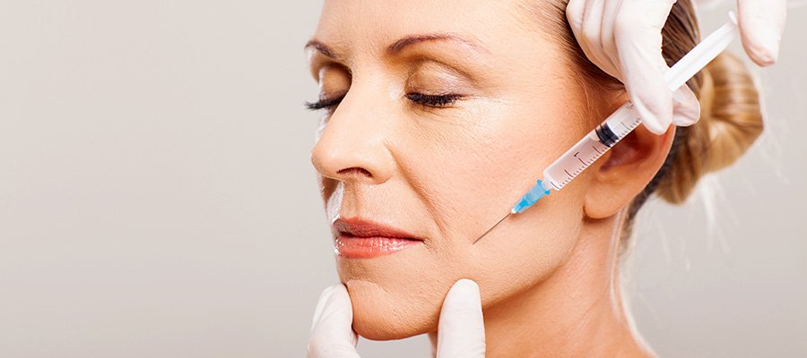 Senior woman receiving cheek filler injectable